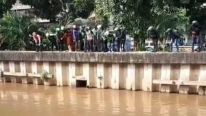 Screenshot rekaman video seorang pria diduga debt collector motor nekat terjun ke sungai Ciliwung, Gunung Sahari, Jakarta Pusat lantaran takut dihajar massa, Senin (19/04/2021). (Dok. Instagram @jakarta.terkini)