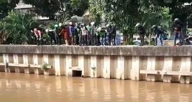 Screenshot rekaman video seorang pria diduga debt collector motor nekat terjun ke sungai Ciliwung, Gunung Sahari, Jakarta Pusat lantaran takut dihajar massa, Senin (19/04/2021). (Dok. Instagram @jakarta.terkini)
